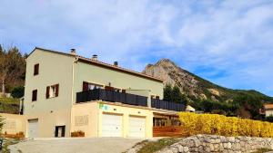 une maison blanche avec une montagne en arrière-plan dans l'établissement Entre Ciel et Verdon, à Castellane