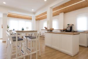 a kitchen with white cabinets and bar stools at B&B La Camia in Castel di Sangro