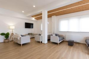 a living room with white furniture and a large window at B&B La Camia in Castel di Sangro