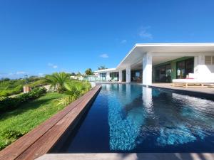 a swimming pool in front of a house at Les Voiles Bleues in Saint-François
