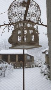a bird feeder with snow on it in a yard at Agriturismo Cascina Knec in Feisoglio