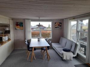 ein Wohnzimmer mit einem Tisch und einem Sofa in der Unterkunft Øster Hurup in Hadsund