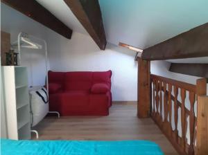 un sofá rojo en una habitación con escalera en Maison T2 Terrasse Mezzanine, en Le Grau d'Agde