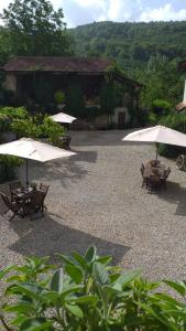 eine Terrasse mit Stühlen und Sonnenschirmen vor einem Gebäude in der Unterkunft Agriturismo Cascina Knec in Feisoglio