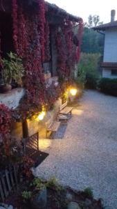 eine Gruppe von Bänken vor einem Gebäude mit Blumen in der Unterkunft Agriturismo Cascina Knec in Feisoglio