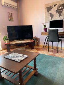 a living room with a coffee table and a television at Casa Marta in Beniarjó