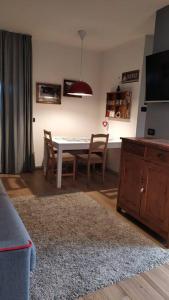 uma sala de estar com uma mesa de jantar e cadeiras em Mini Midlake codice cipat 022229-AT-410061 em Mezzolago