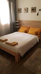 um quarto com uma cama grande e almofadas amarelas em Mini Midlake codice cipat 022229-AT-410061 em Mezzolago