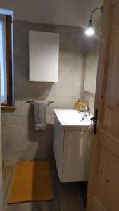 uma casa de banho com um lavatório branco e um espelho. em Mini Midlake codice cipat 022229-AT-410061 em Mezzolago