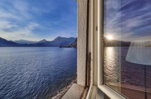 a window with a view of the water and mountains at Margherita House in Varenna