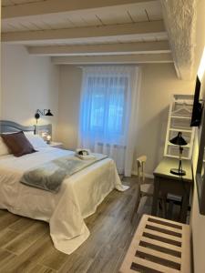 1 dormitorio con cama, mesa y ventana en Hostal Cal Pericas, en La Pobla de Lillet