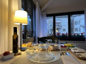 uma mesa com uma garrafa de vinho e copos em Hostal Cal Pericas em La Pobla de Lillet