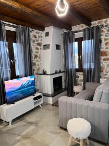 a living room with a couch and a flat screen tv at Double Bee Villa with private pool in Agios Konstantinos