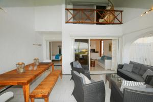 a living room with a wooden table and chairs at Caro's Beachfront in Trou aux Biches