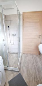 ein Bad mit einer Dusche und einer Glastür in der Unterkunft Umago Inn in Umag