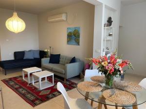 ein Wohnzimmer mit einem Tisch und einem Sofa in der Unterkunft charming tlv two bedroom in Tel Aviv