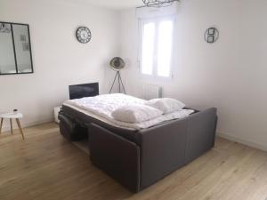 een bed in een kamer met witte muren en een raam bij Le Chaleureux, accueillant, gare, parking gratuit in Le Mans