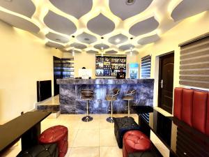 a bar in a restaurant with a counter and stools at Buddiez Hotel & Resort in Enugu