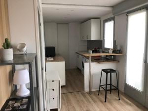 a small kitchen with white cabinets and a table at Studio de charme sous les pins au calme in La Baule +4 photos