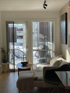 a living room with a couch and a balcony at Leilighet sentralt i Tromsø in Tromsø