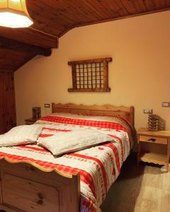 a bedroom with a bed with a red and white blanket at La Mansarda di Casa Vacanze La Vite in Bordogna