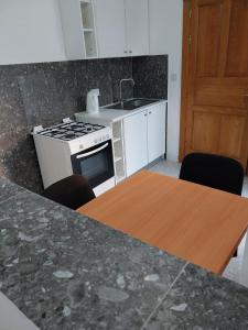 a kitchen with a sink and a stove and a table at Whitestar Guesthouse in Salina