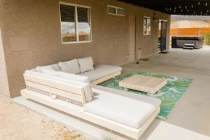 ein Wohnzimmer mit 2 Betten und einem Sofa in der Unterkunft Cheerful 2bedroom home with hot tub and cowboy pool in Joshua Tree in Joshua Tree