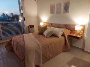 a bedroom with a bed with two lamps and a window at Apartamento Hygge 42 in La Plata