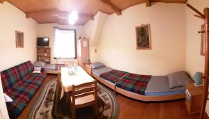 a living room with two beds and a table at Willa Świt in Maków Podhalański
