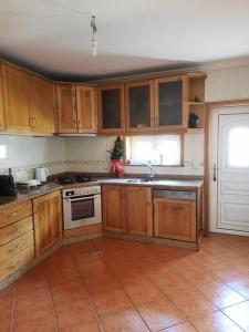 una cucina con armadi in legno e pavimento piastrellato di Casa ideal para grupos ou casais a Espargo