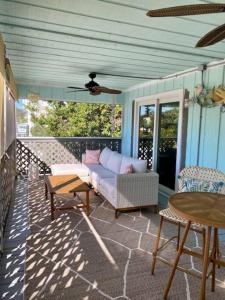 eine abgeschirmte Veranda mit einem Sofa und einem Tisch in der Unterkunft Kokomo- Canal front 2b/1bath home in Big Pine Key + 3 Fotos