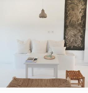 sala de estar blanca con mesa y sofá en JOA guesthouse, entre Bayonne et océan, en Boucau