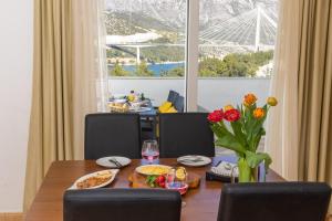 a dining room with a table with food and flowers at Villa Erna in Dubrovnik