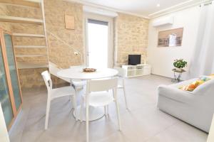 un piccolo soggiorno con tavolo e sedie bianchi di In the heart of Marina di Ragusa a Marina di Ragusa