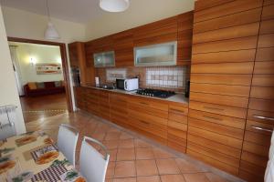 拿坡里的住宿－Casa Diocleziano，厨房配有木制橱柜和桌椅