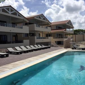 un hotel con piscina frente a un edificio en Lagun Sunset Resort All Natural Clothing Optional, en Lagun