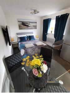 a room with a bed and a table with flowers on it at Luxury Town Center Studio Stevenage in Stevenage