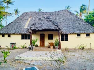 uma casa com telhado de palha em Ushongo Beach Cottages - Family House em Tanga
