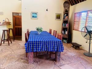 uma mesa num quarto com uma toalha de mesa de xadrez azul em Ushongo Beach Cottages - Family House em Tanga