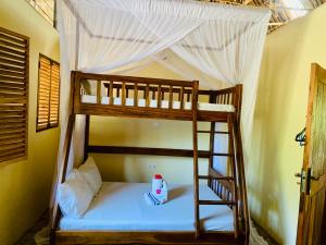 a bunk bed in a room with a ladder at Ushongo Beach Cottages - Family House in Tanga