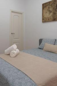 Una cama con dos toallas enrolladas encima. en Suite Alhambra Puerta Bib-Rambla, en Granada