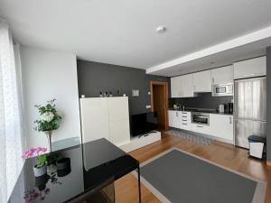 Una cocina con gabinetes blancos y una encimera negra. en Elcano Bermeo By Urdaibai Rentals, en Bermeo