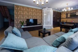 a living room with a couch and a tv and a table at Amber House in Liepāja