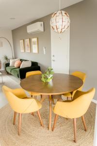 uma sala de jantar com uma mesa de madeira e cadeiras amarelas em Cheerful 2bedroom home with hot tub and cowboy pool in Joshua Tree em Joshua Tree