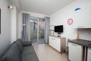 a living room with a couch and a tv at Miramare_5 appartamento in Castelsardo