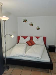 a bed with white and red pillows on it at Studio Mario in Alberschwende