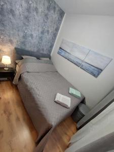 um pequeno quarto com uma cama e uma janela em LAKE APARTMAN em Balatonfüred