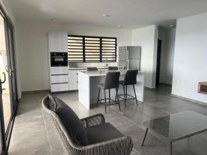 a kitchen with a couch and chairs and a table at Lagun Sunset Resort All Natural Clothing Optional in Lagun