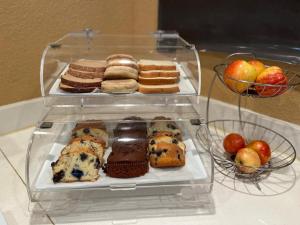 a glass display case with different types of cakes and apples at MorningGlory Inn & Suites in Bellingham