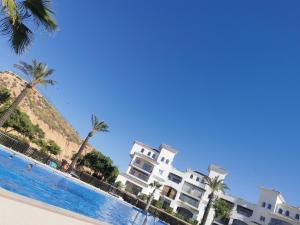 a row of white buildings next to a swimming pool at Casa Muir in Sucina